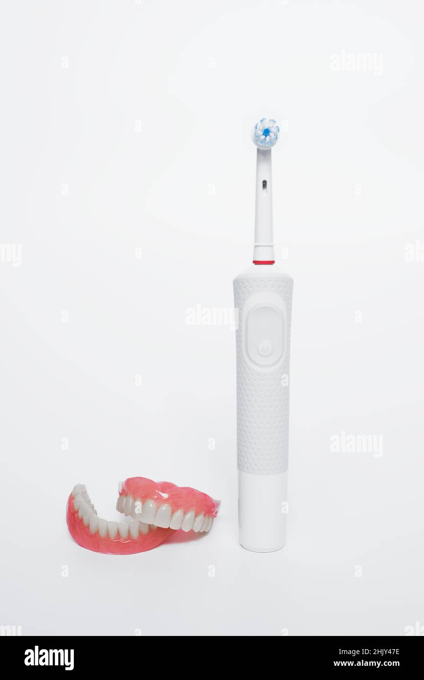 Dental care with an electric brush. Dentures and an electric brush on a