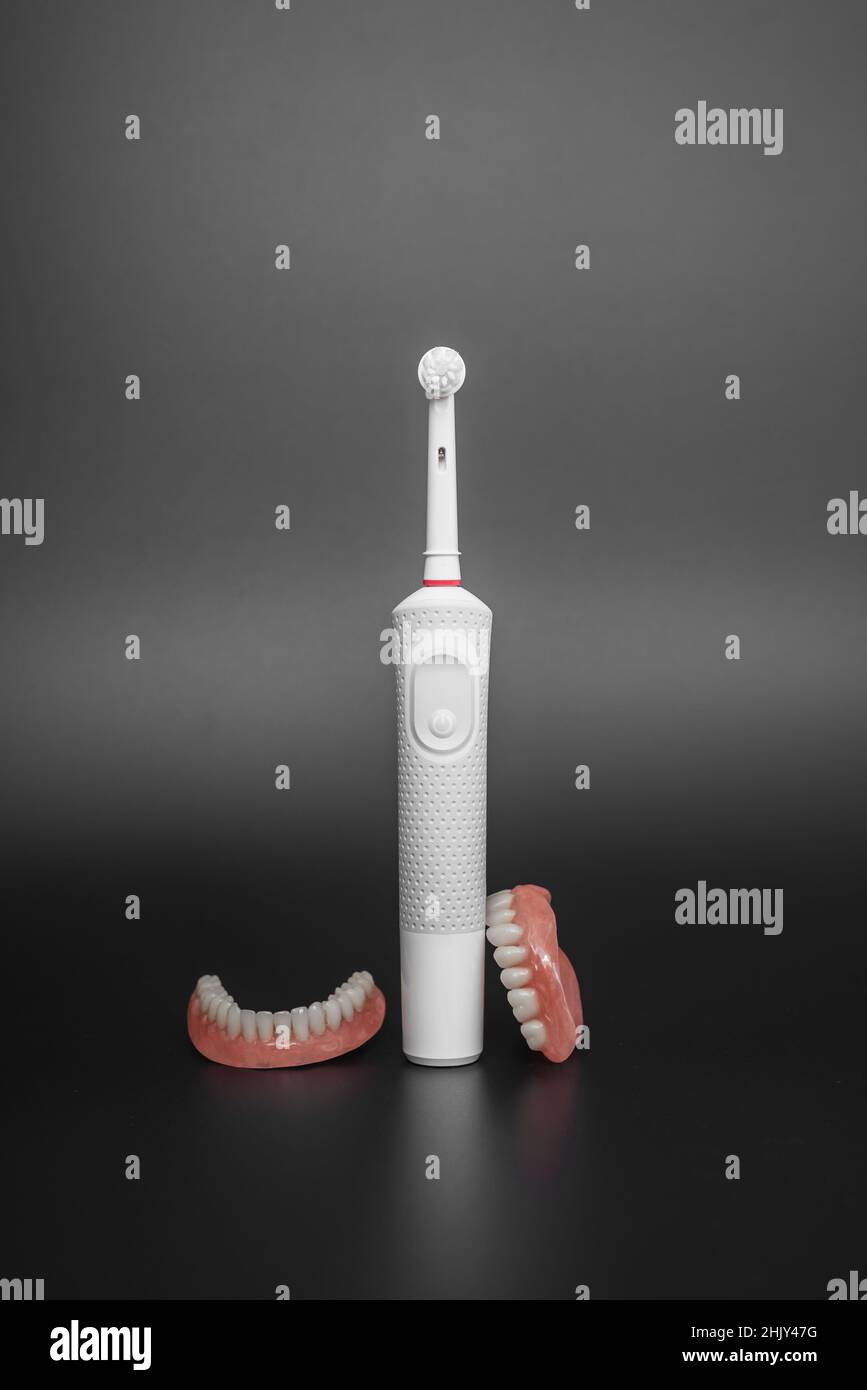 Dental care with an electric brush. Dentures and an electric brush on a