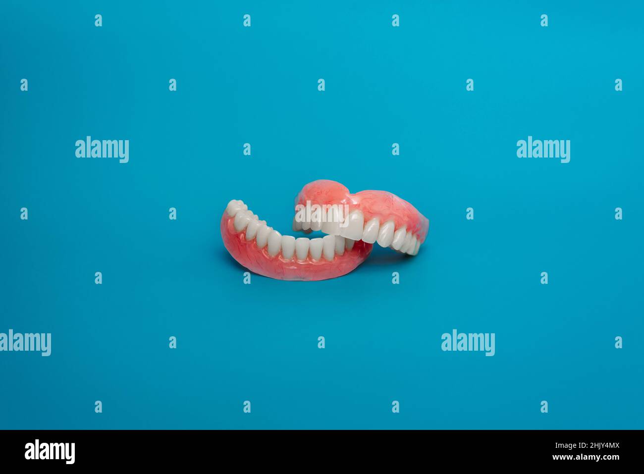 Full removable plastic denture of the jaws. Set of dentures on a blue