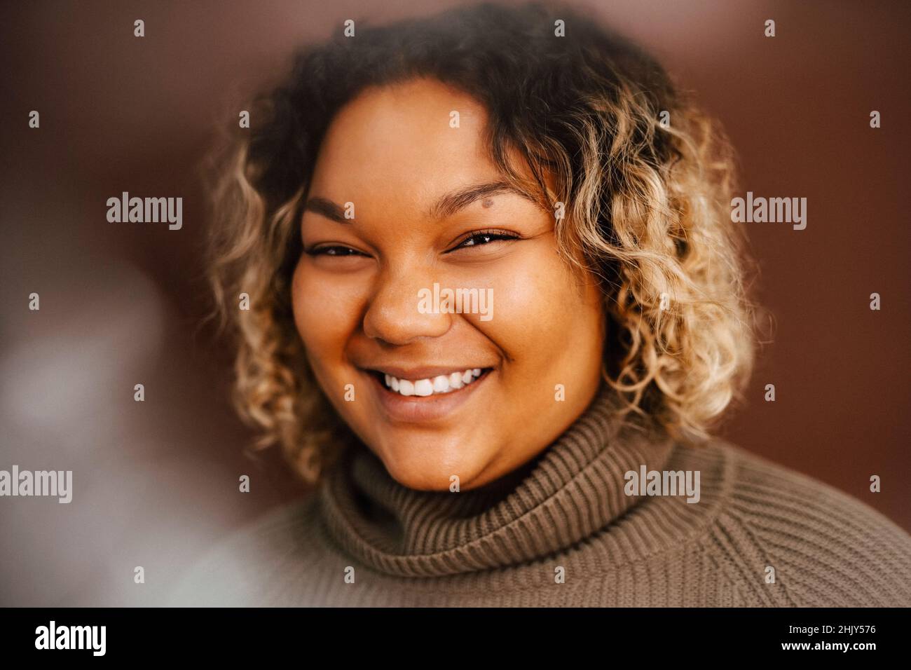 Portrait of happy young woman in studio Stock Photo