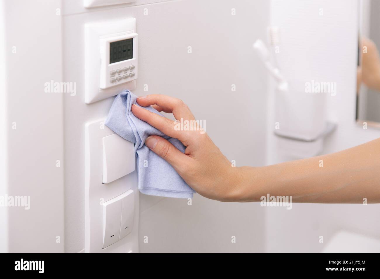 Cleaning switches and sockets with a microfiber cloth. Woman hand using ...