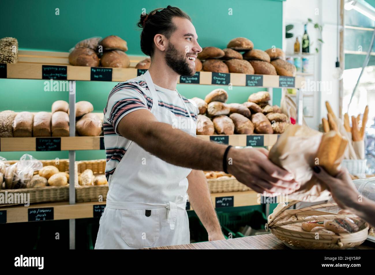 Smiling male owner giving bread to customer in bakery Stock Photo Alamy
