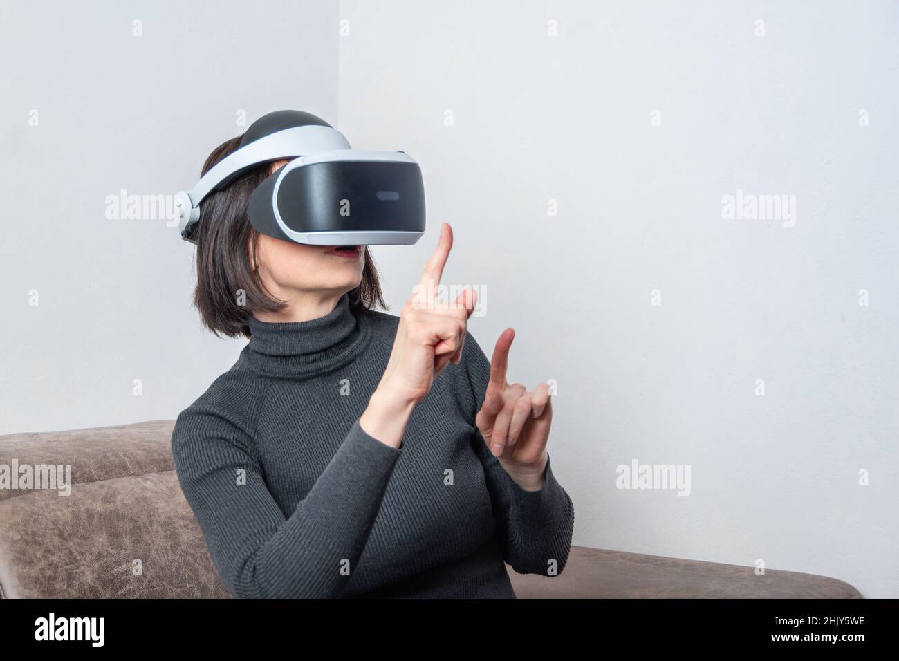 Teen girl using vr headset is in virtual reality cyberspace. The concept of the metaverse, virtual reality, virtual social universe. Future digital te Stock Photo
