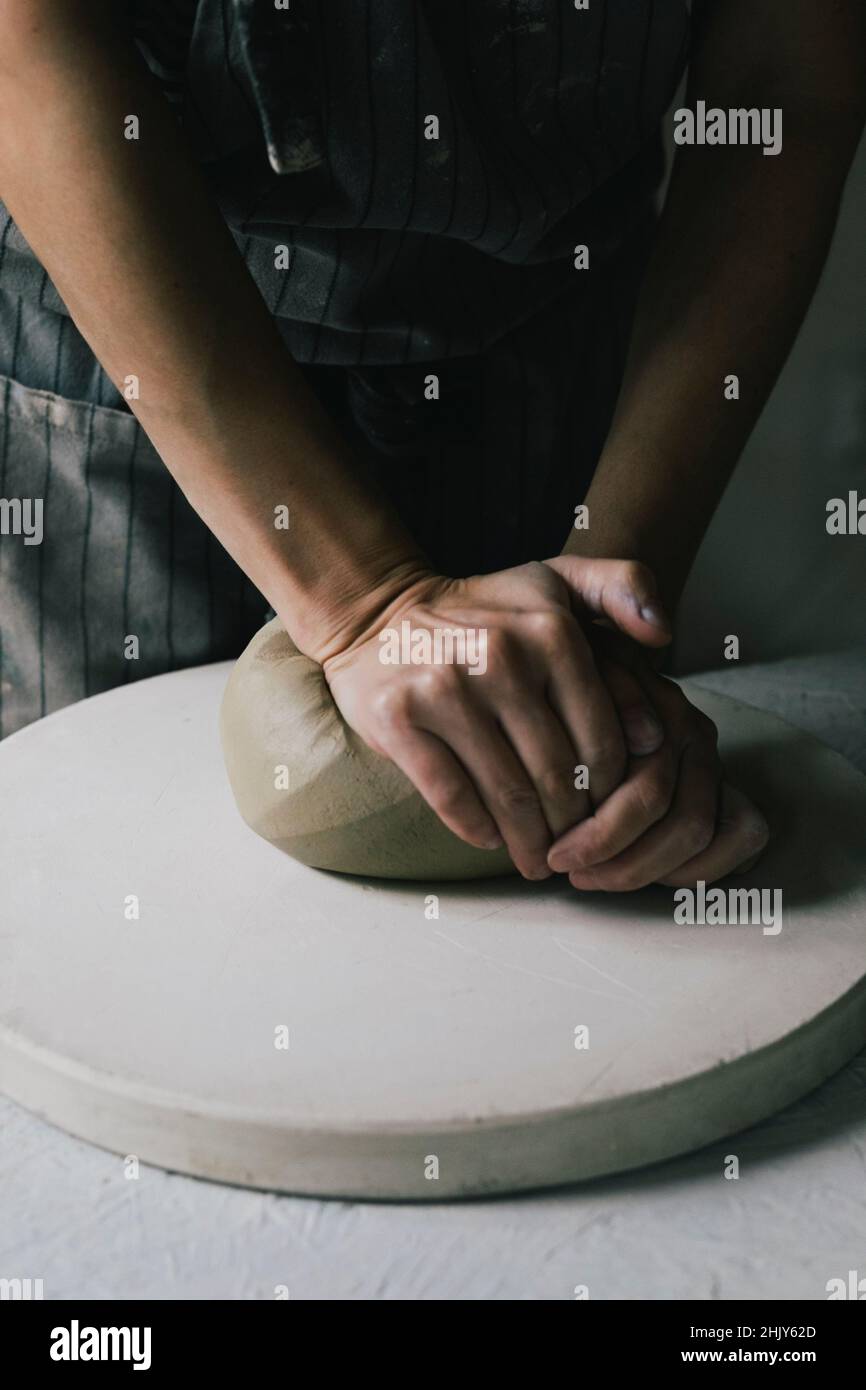 Midsection of craftswoman kneading clay in workshop Stock Photo