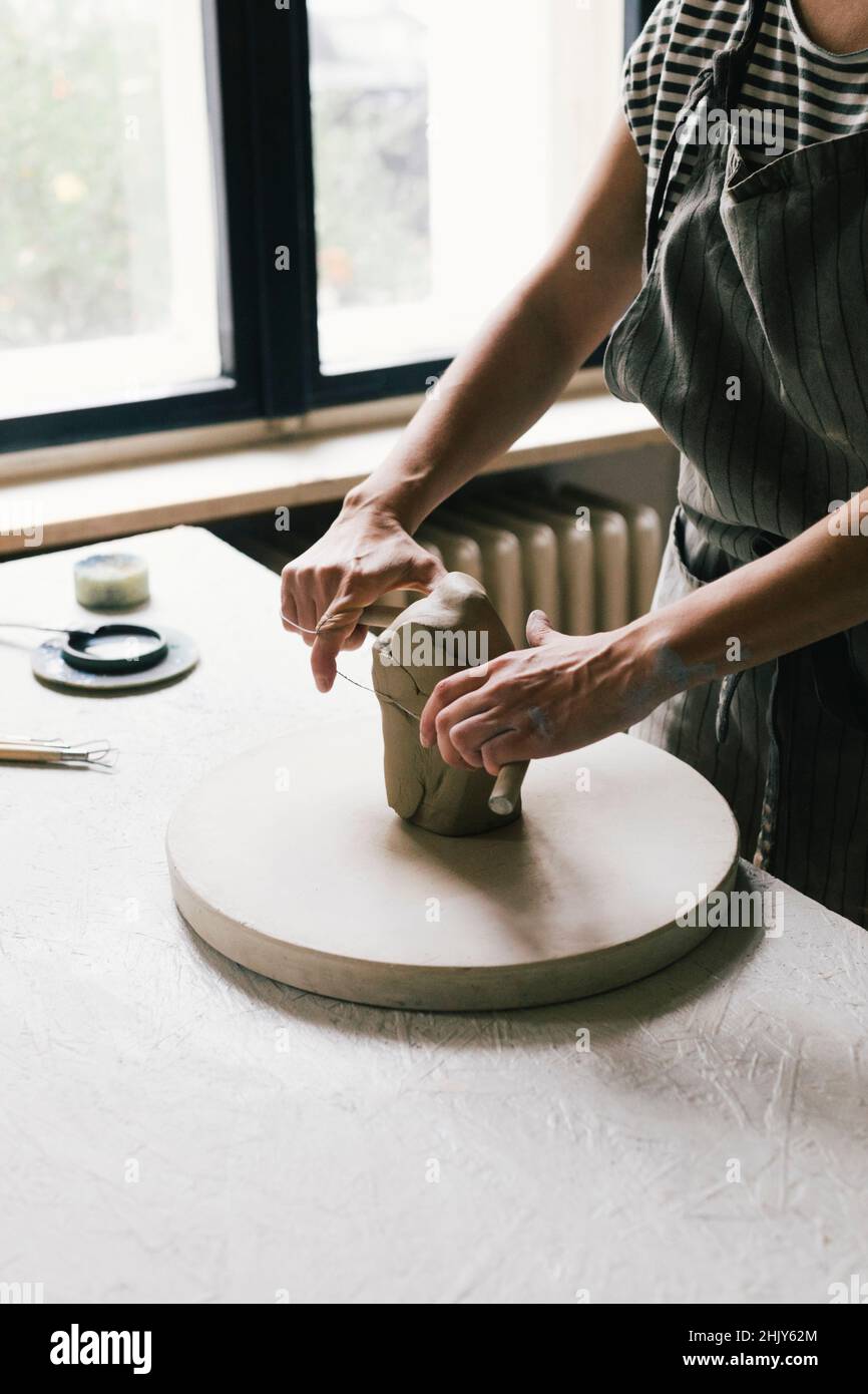 Midsection of female owner kneading clay in workshop Stock Photo