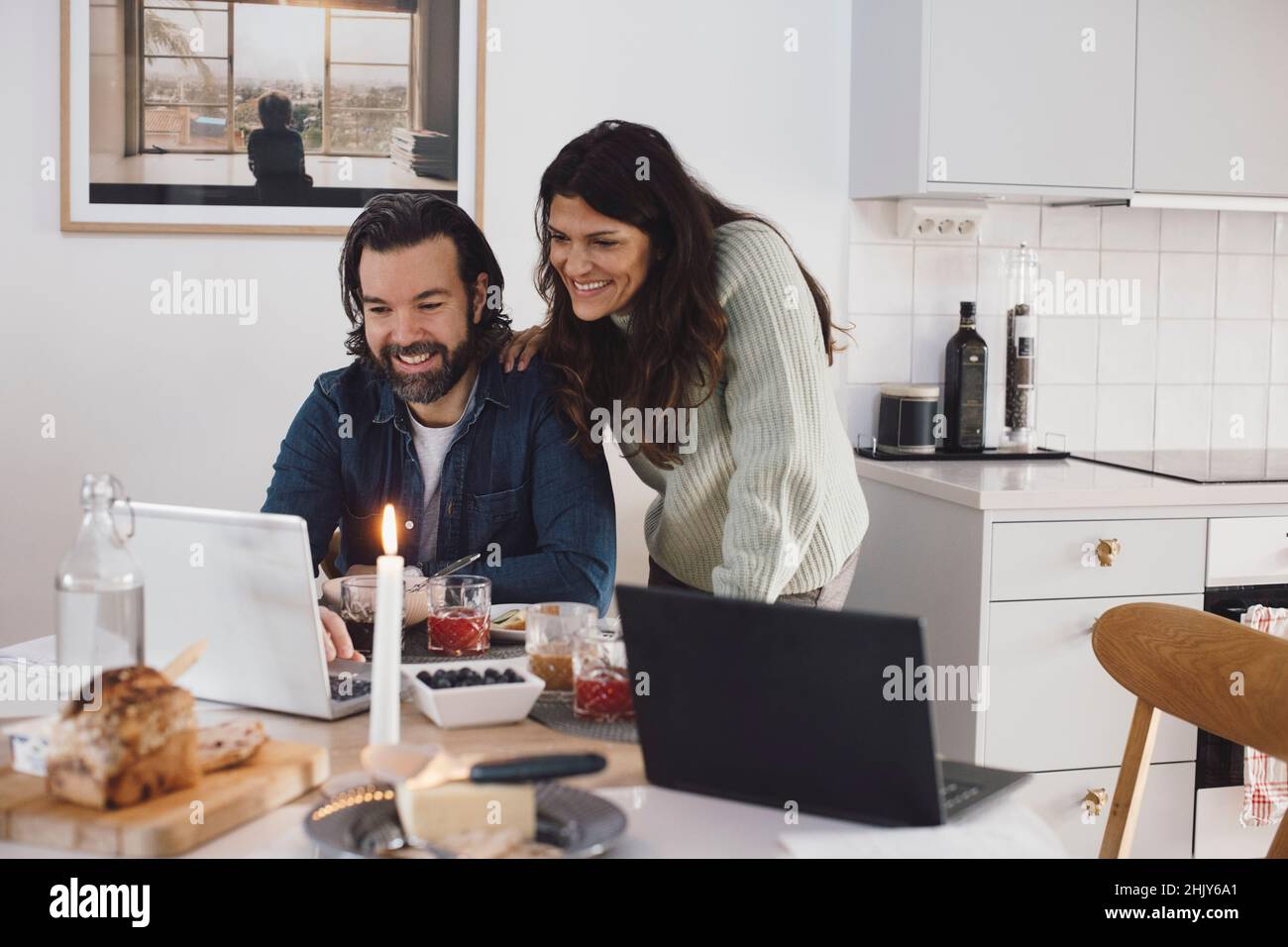 Smiling mature couple using laptop at home Stock Photo