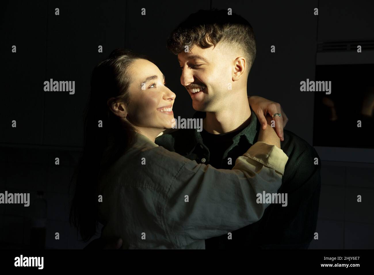 Smiling couple looking at each other with sunlight on faces Stock Photo