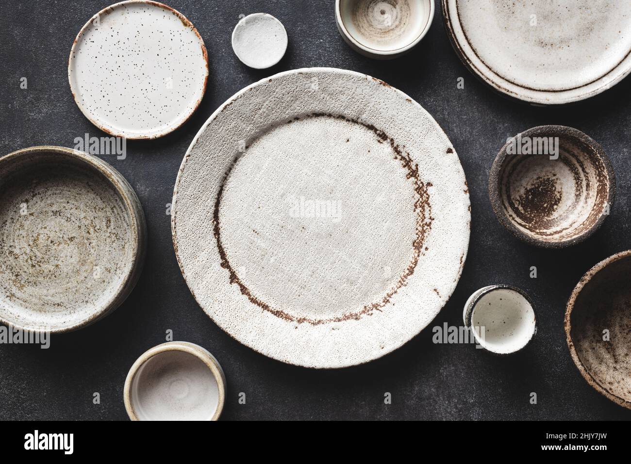Modern Trendy Craft Ceramic Plates And Bowls On Concrete Table Background. Top View Copy Space. Kitchenware Stock Photo