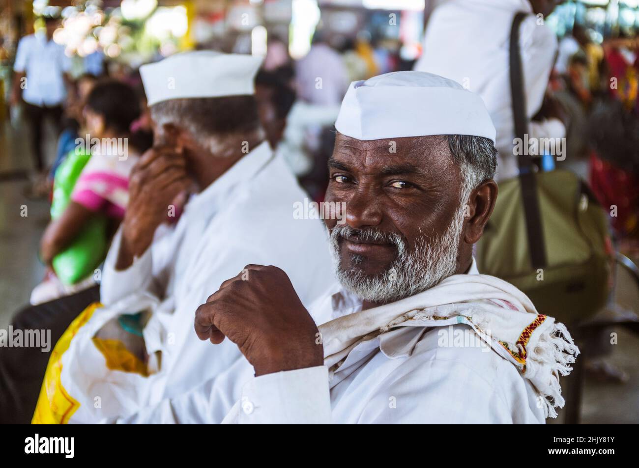 Bijapur, Karnataka, India : Portrait of a friendly Indian man wearing a white Gandhi cap at  Bijapur Bus Stand. Stock Photo