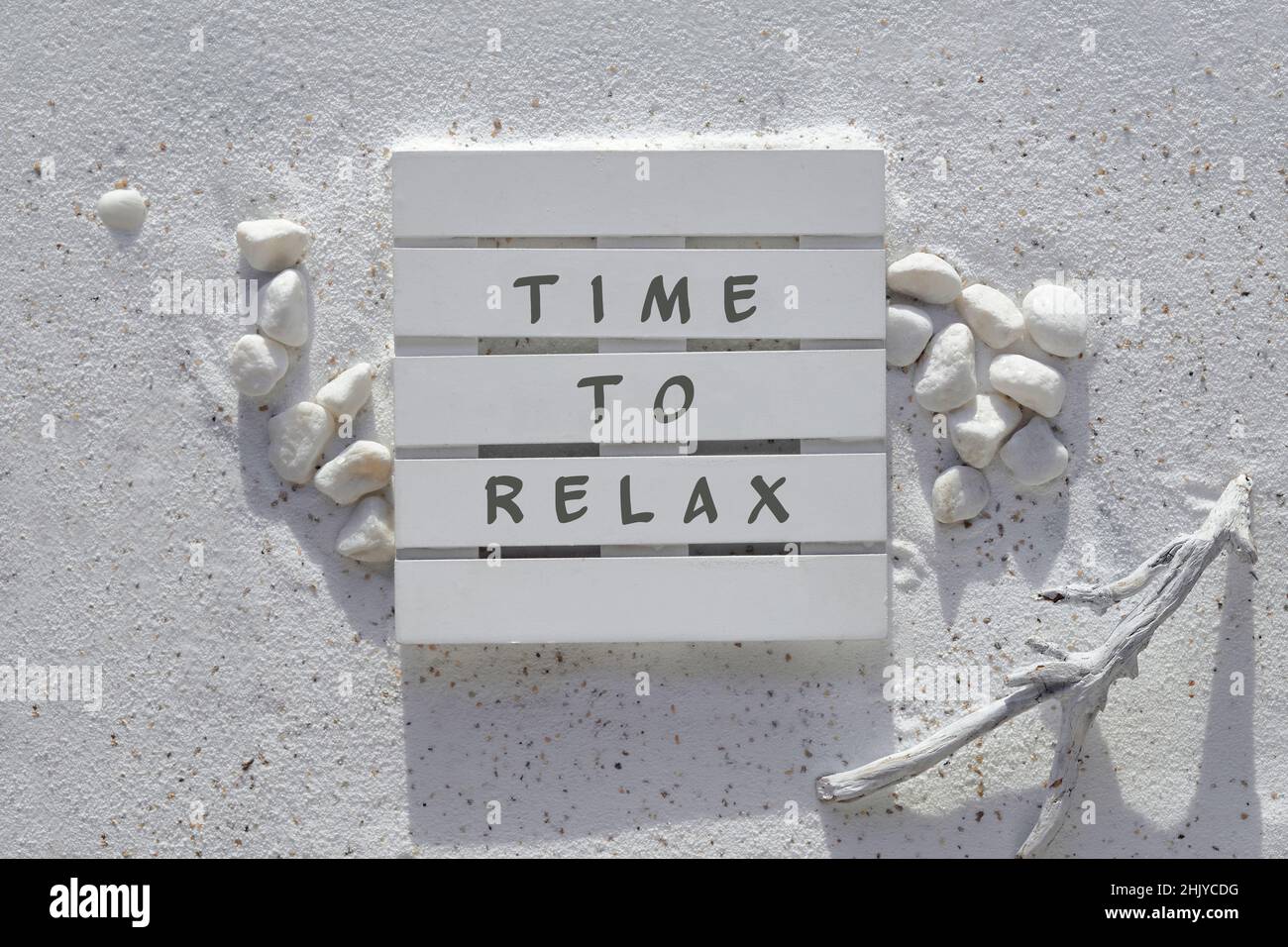 Sand and sea background. Text time to relax. White sand with pebbles and driftwood. Stock Photo