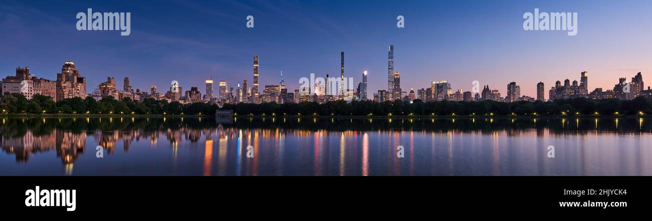 Panoramic New York City skyline. Manhattan skyscrapers from Central Park Reservoir at Dusk. Evening view of billionaires' row super tall luxury buildi Stock Photo