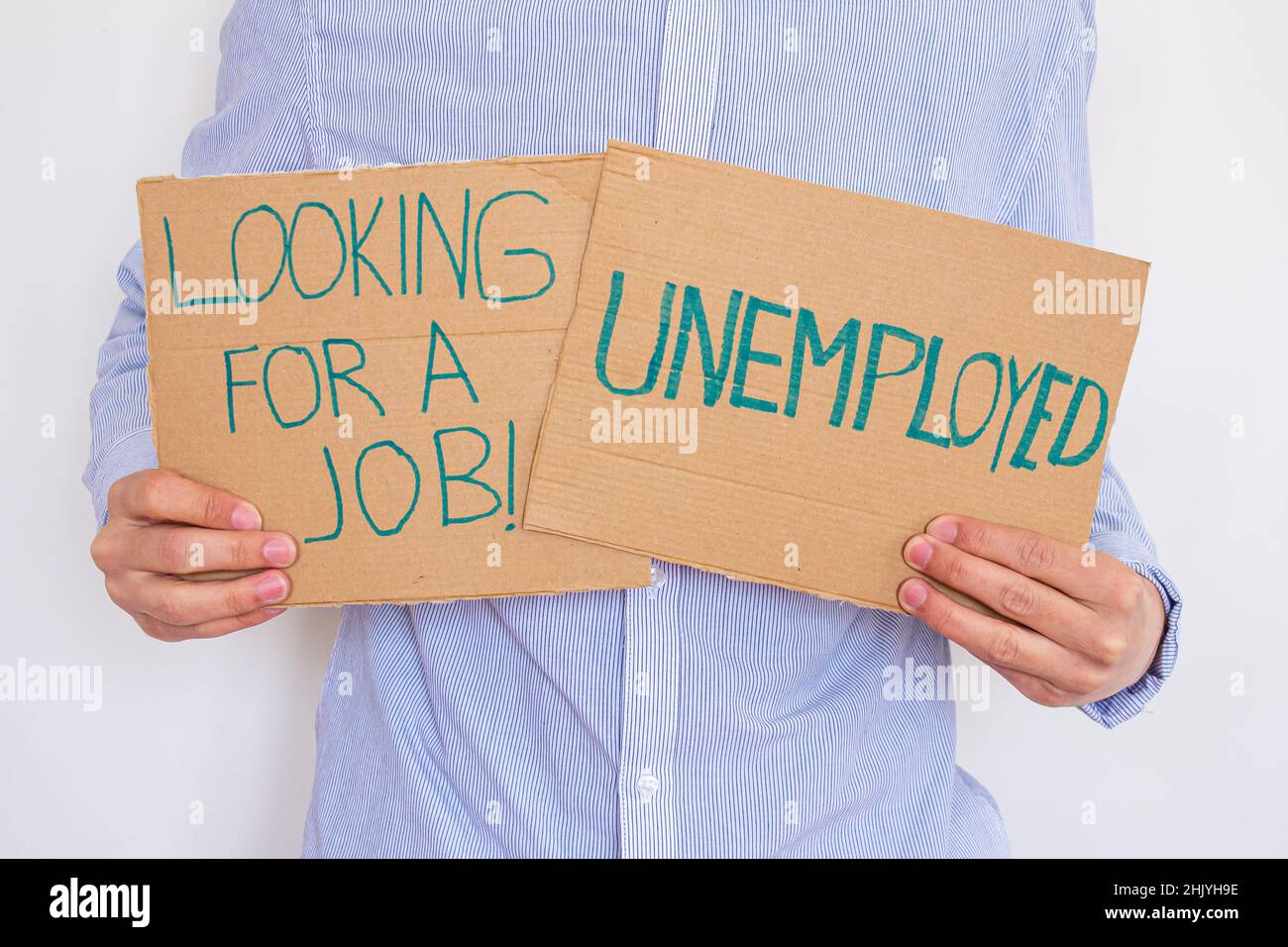 Unemployed man holding sign board with inscription LOOKING FOR A JOB. Concept of losing job and looking a new one. He is having financial problems. Stock Photo