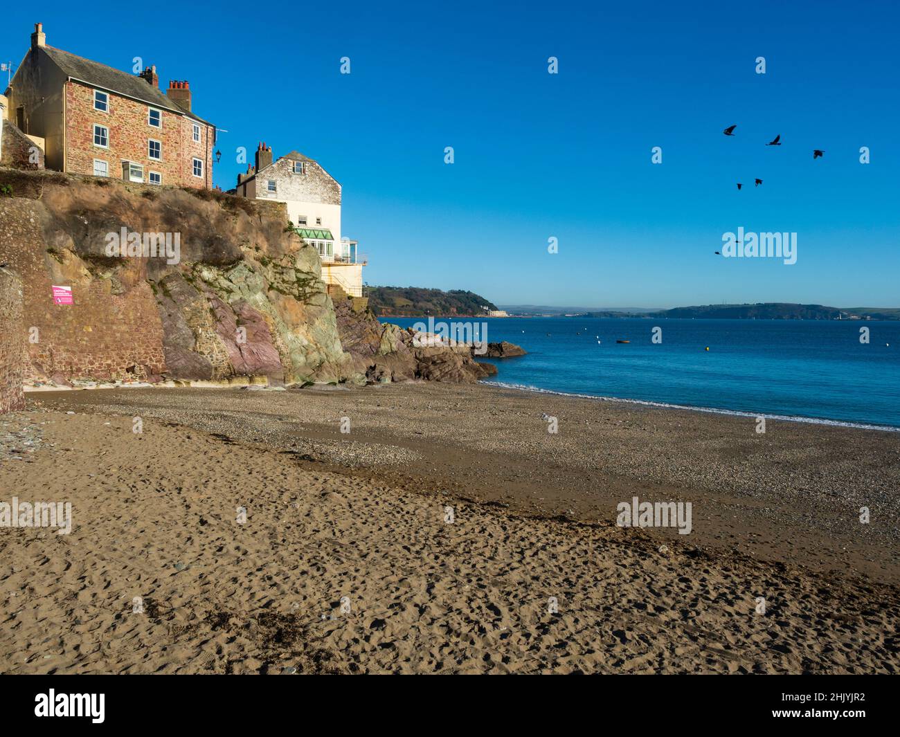 Cawsand, Cornwall, beach and clifftop houses on the edge of Plymouth Sound in bright winter sunlight Stock Photo