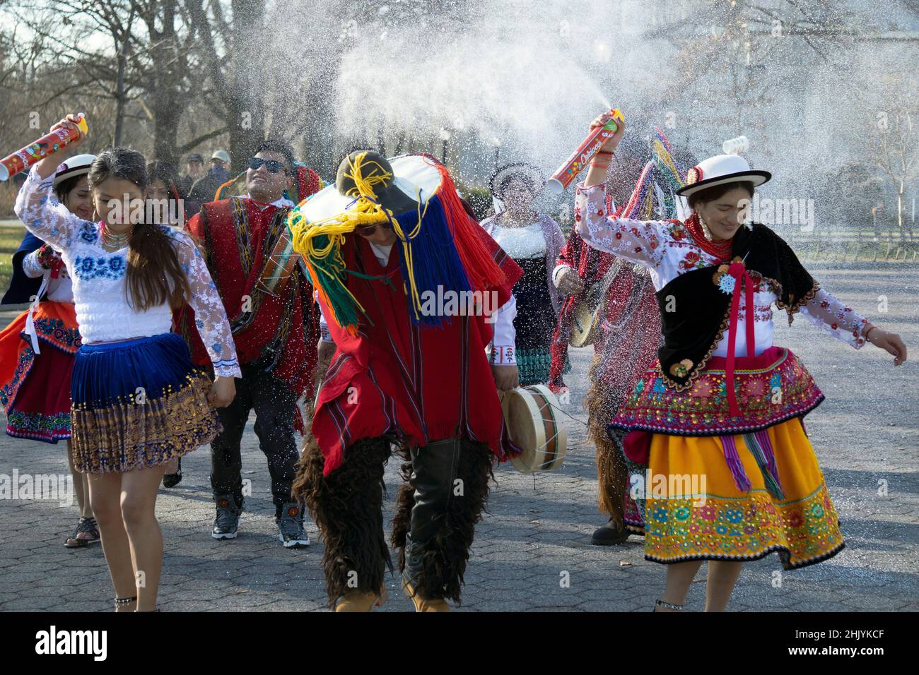 Men and women Ecuadorian New Yorkers dance & play music while spraying Carioca, a shaving cream type spray used in celebrations. In Queens, New York. Stock Photo