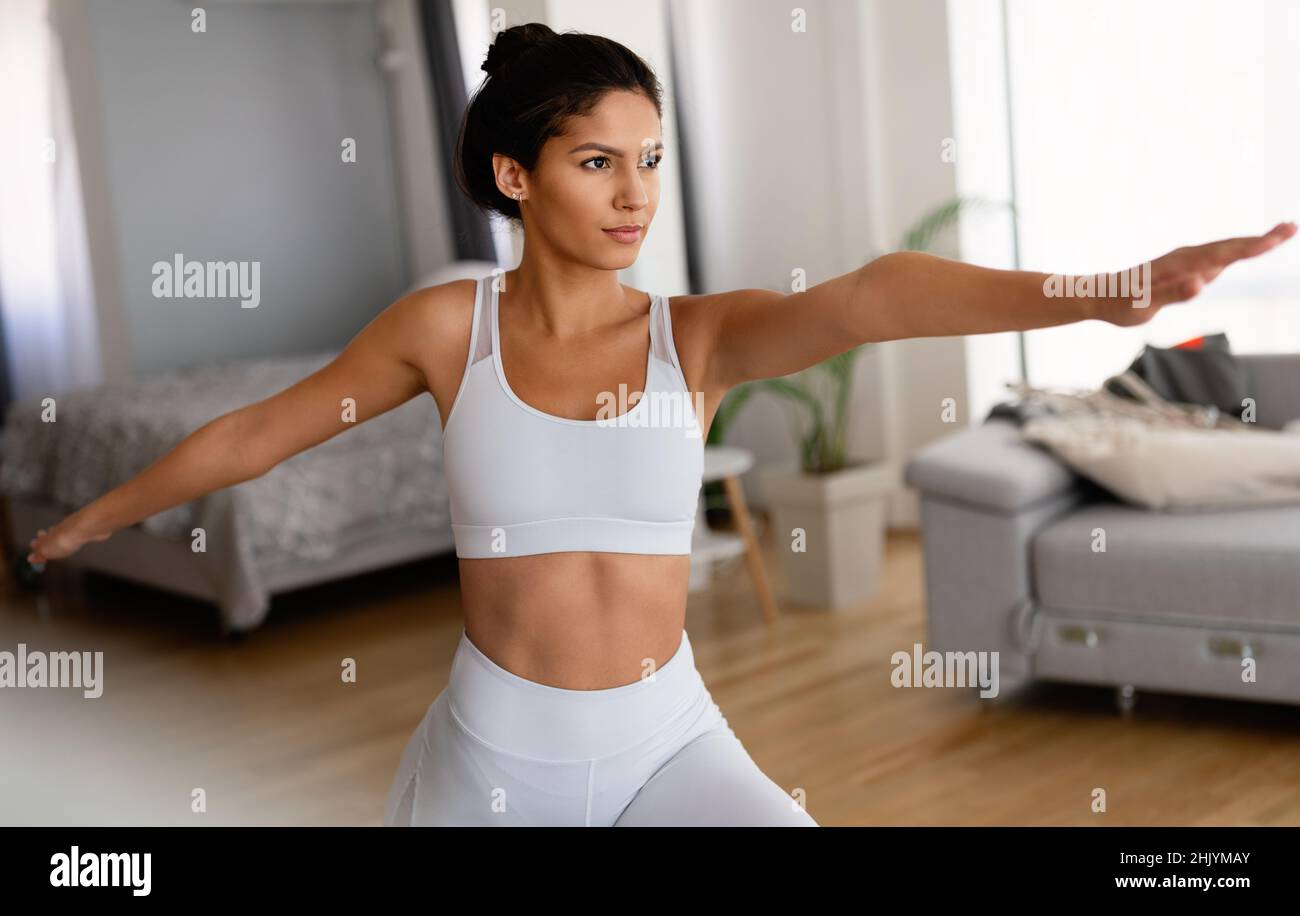 Sporty beautiful woman exercising at home to stay fit Stock Photo