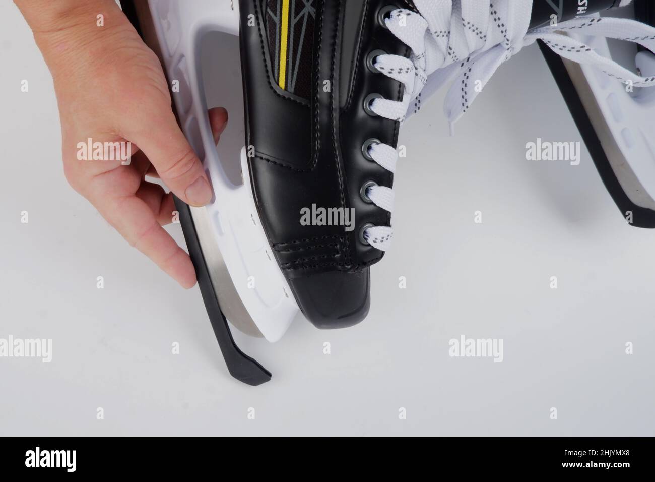 someone puts a protective cover on the blade of ice skates Stock Photo Alamy