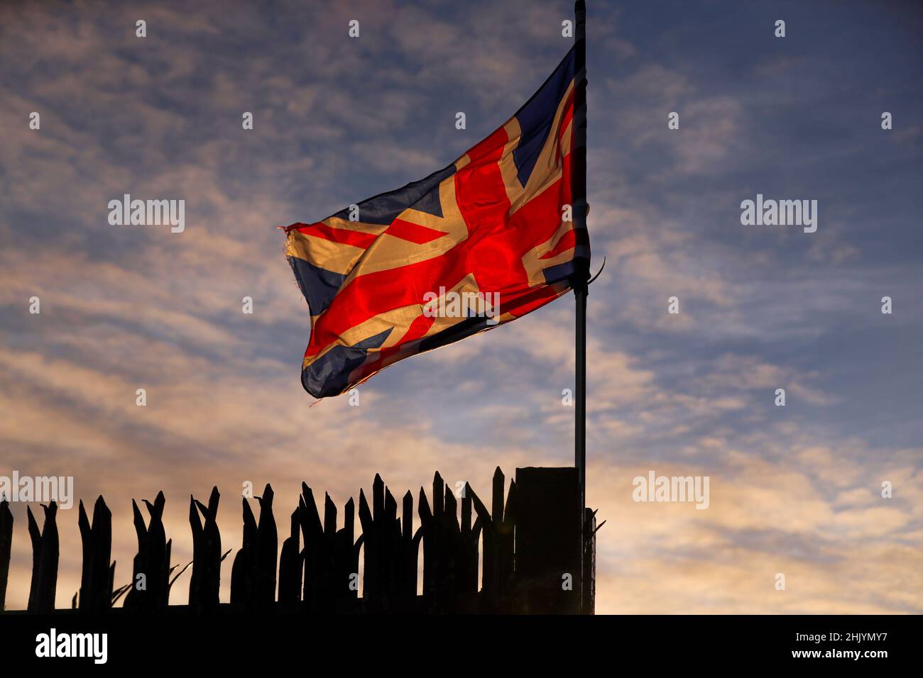 The sun rises over east Belfast as the Union Flag flutters in the wind. Stock Photo