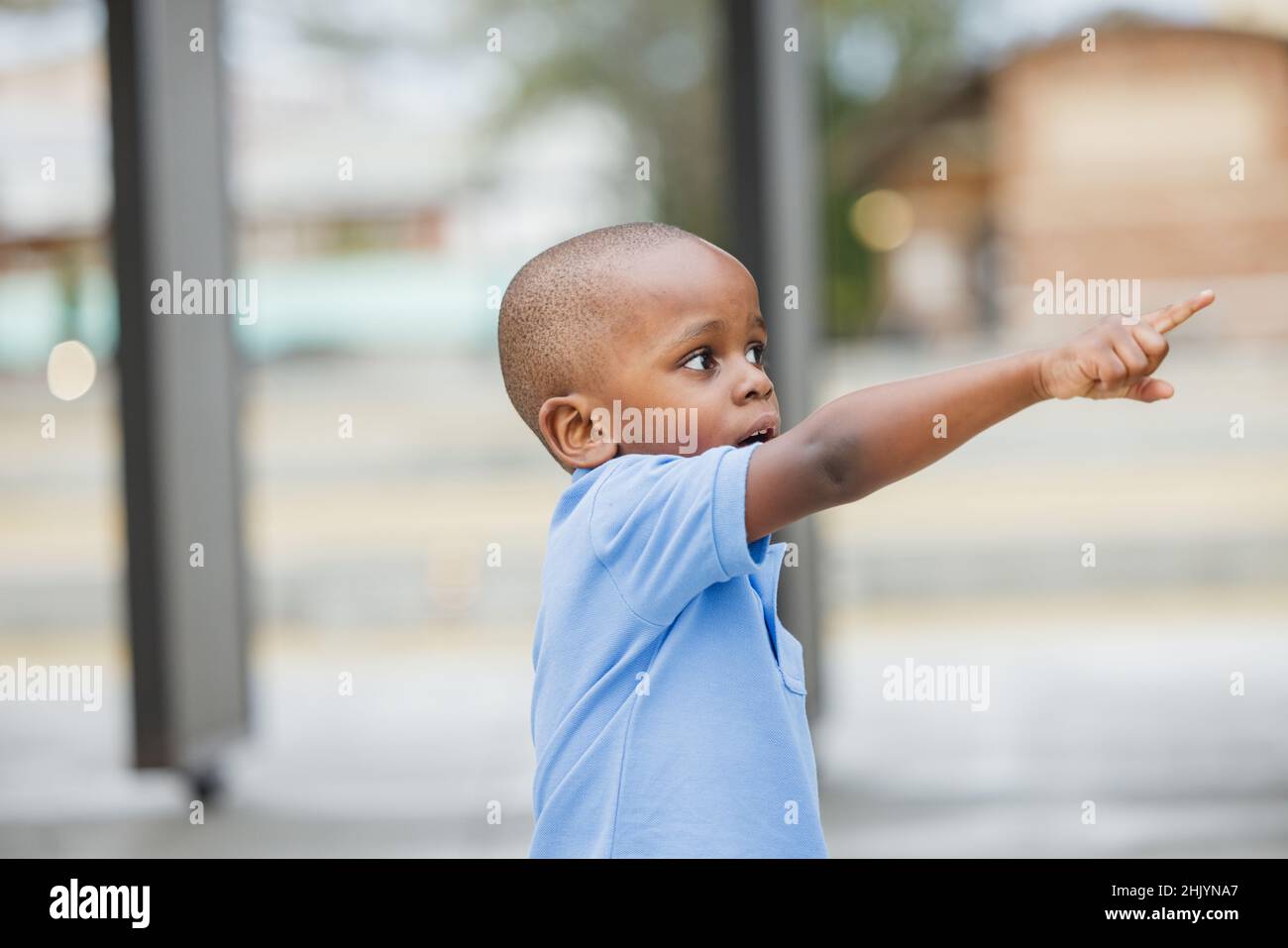 A little boy standing outside and pointing Stock Photo