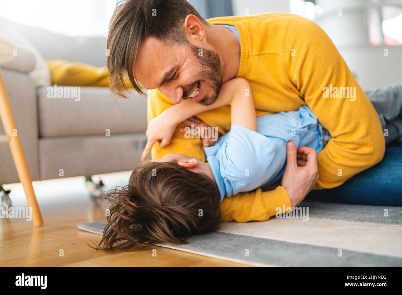 Joyful toddler boy having fun, playing with his father together at home. Stock Photo