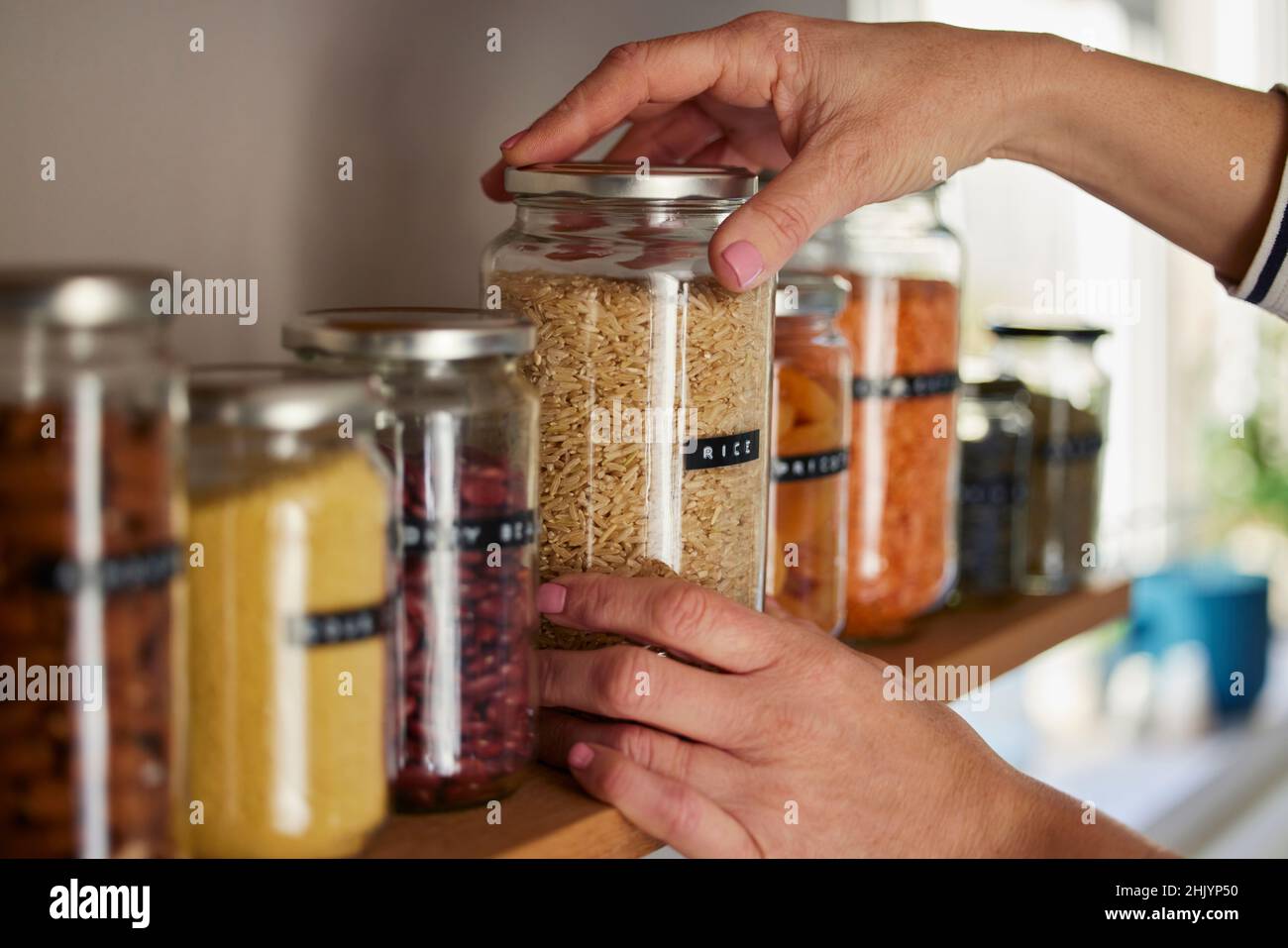 Woman Reusing Glass Jars To Store Dried Food Living Sustainable Lifestyle At Home Stock Photo