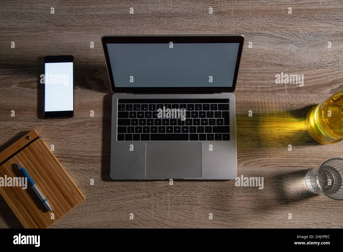 Overhead view of laptop and smart phone on wooden table in office Stock Photo