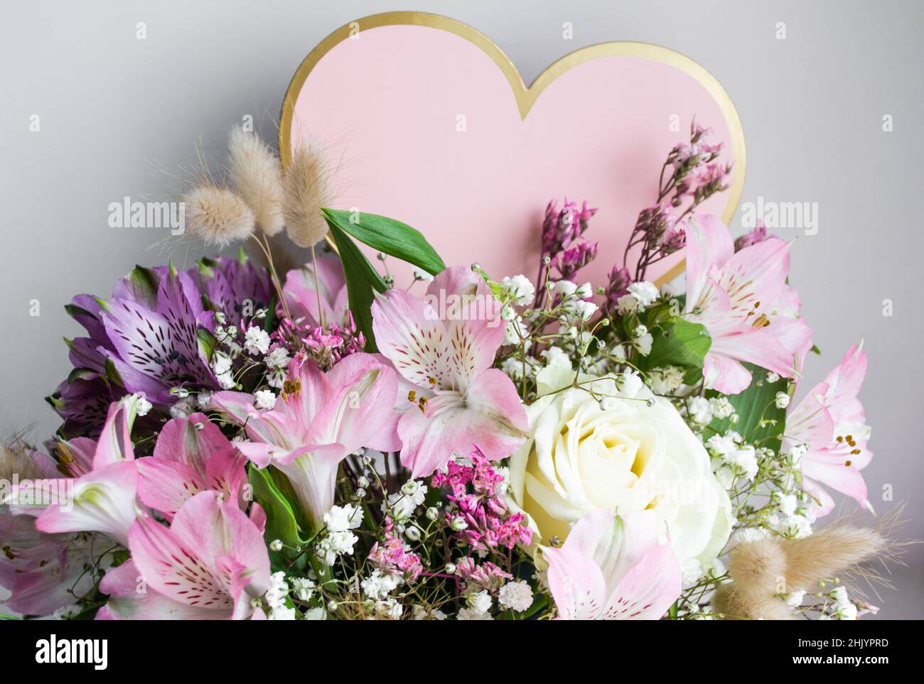 Delicate bouquet of pink lilies, white roses, gypsophiles. White background. Pink Heart, copy