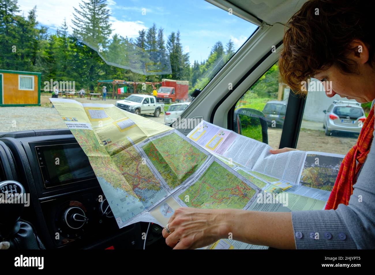 Woman studying a roadmap on her red camper van Stock Photo