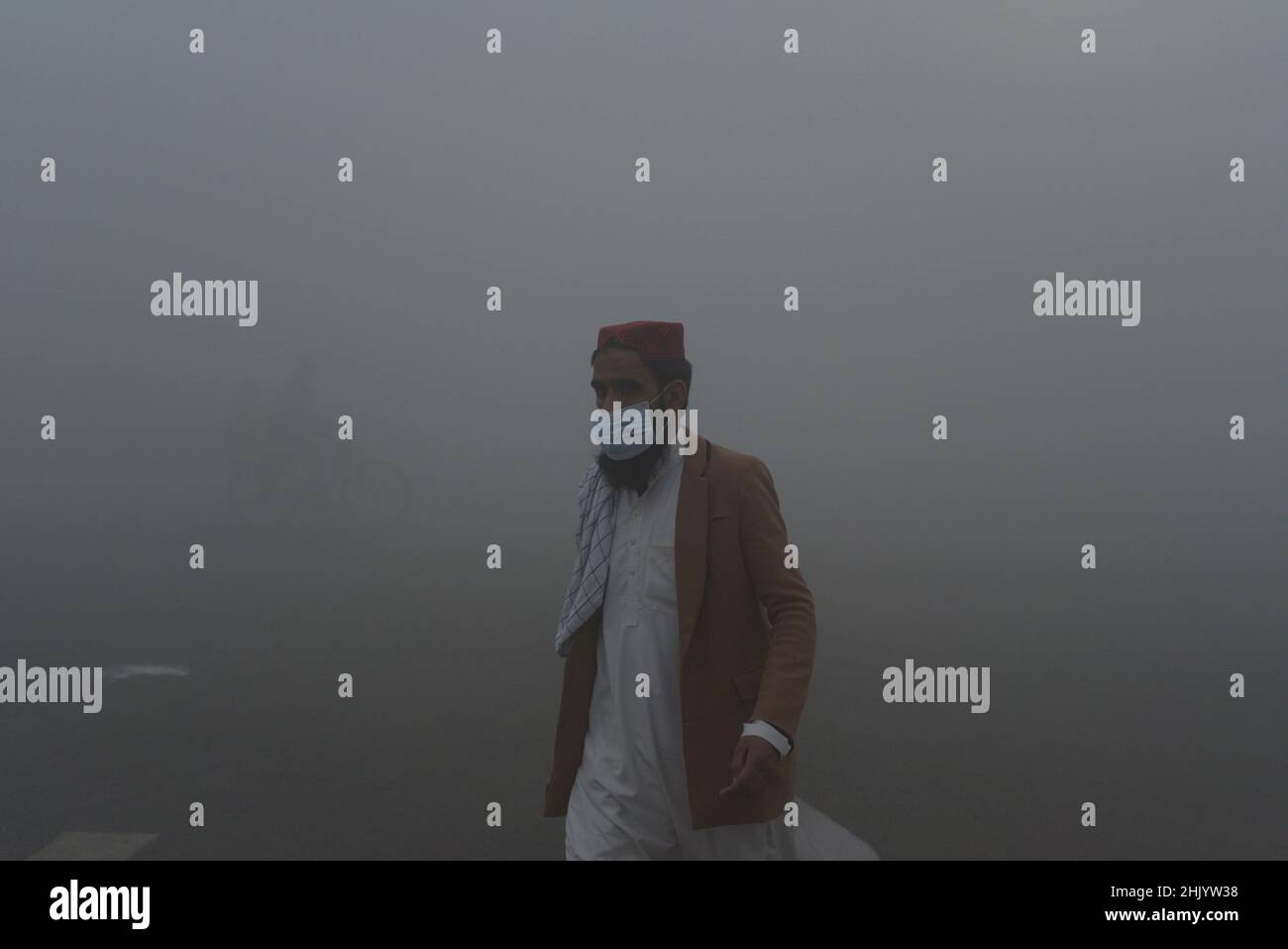 Lahore, Punjab, Pakistan. 1st Feb, 2022. Pakistani citizens and students on their way during a cold and dense foggy morning in Lahore. Pakistani residents and commuters are more worried than surprised due to the sudden layer of dense fog and smog which is causing problems in respiration, visibility and has also hampered smooth flow of traffic, residents of Lahore woke up to a dense blanket of fog and smog on Tuesday that reduced visibility for commuters and prompted several complaints of respiratory problems and mental anguish. (Credit Image: © Rana Sajid Hussain/Pacific Press via ZUMA Pres Stock Photo