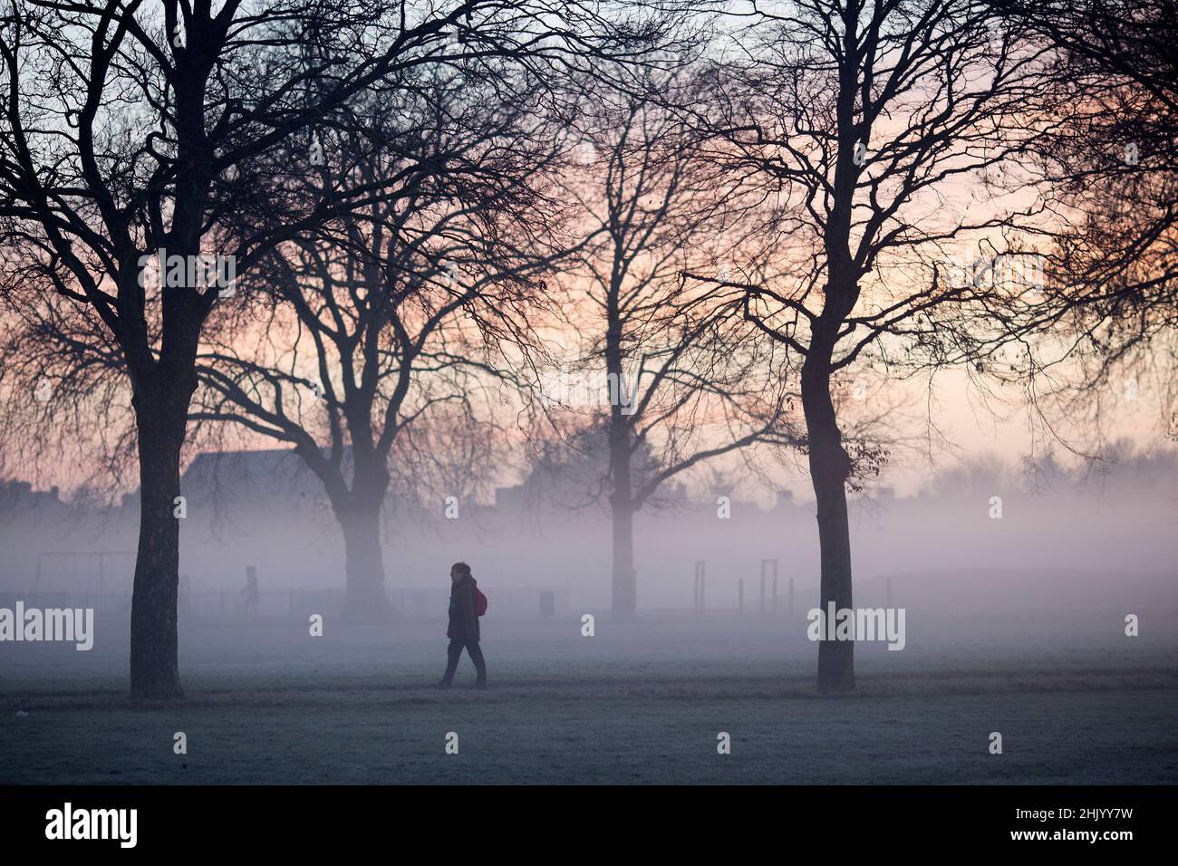 Pedestrians walk in a mistcovered park in Ilford, East London, in the