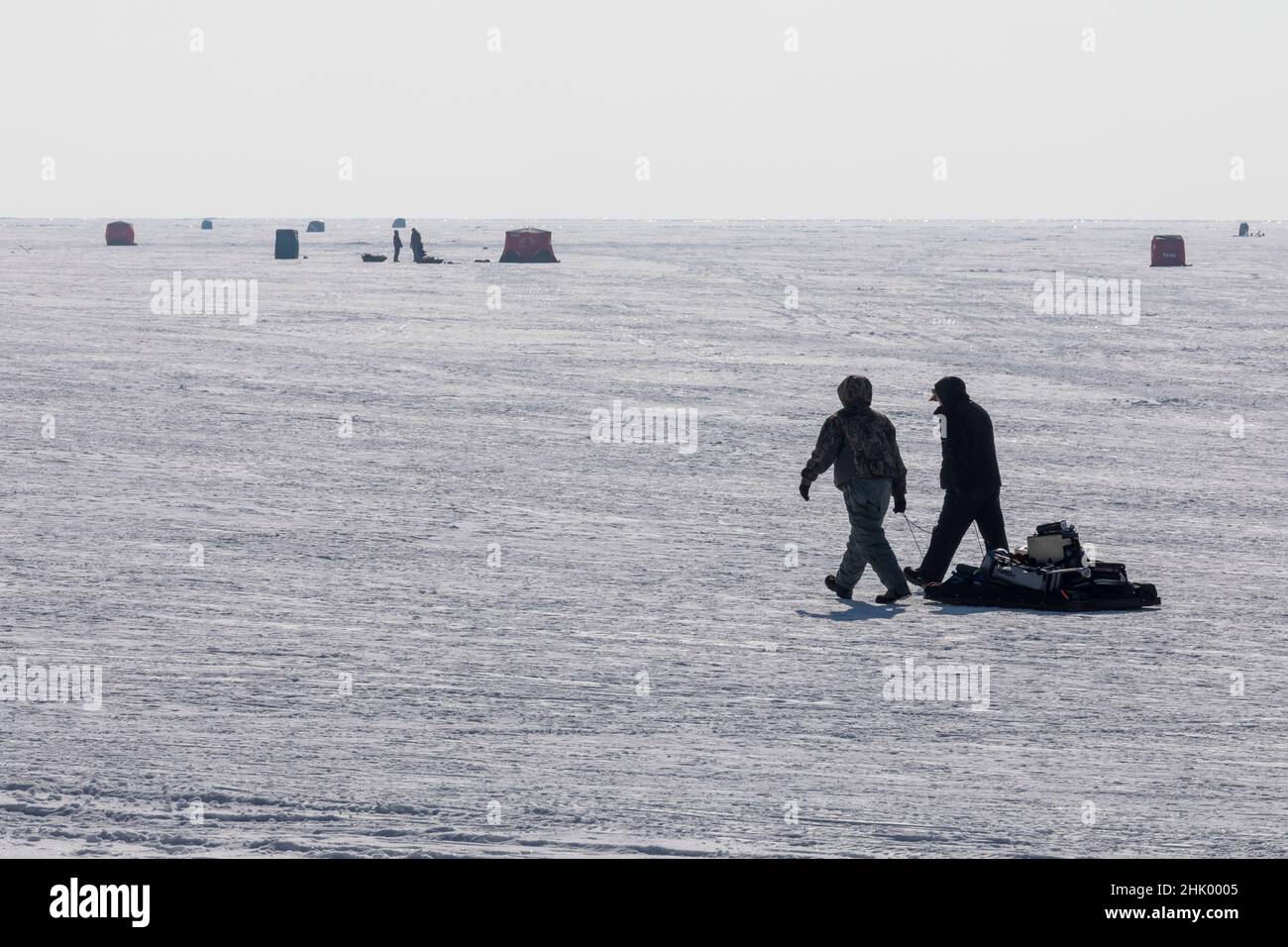 Harrison Township, Michigan - Ice fishermen haul their gear over the frozen surface of Lake St Clair at Lake St Clair Metropark. Stock Photo