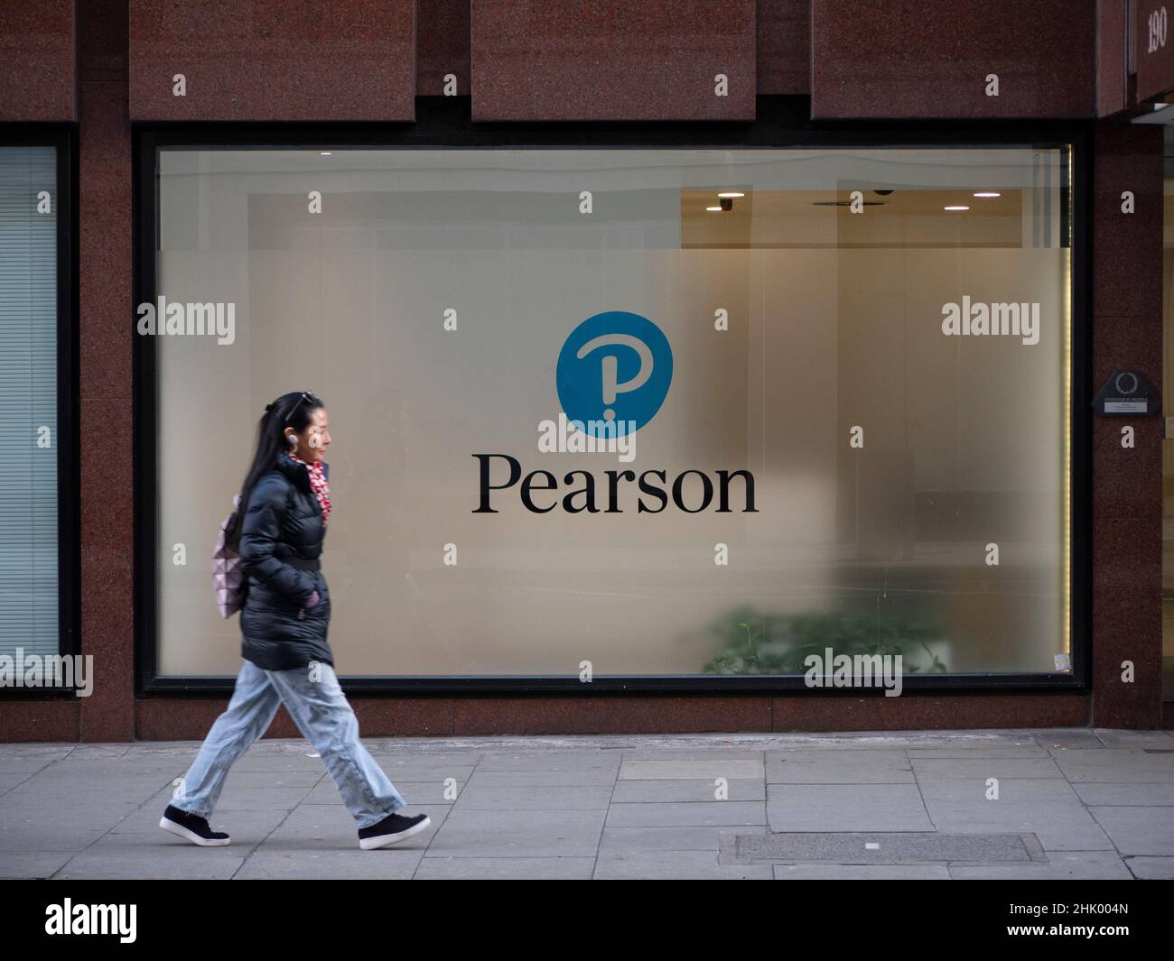 Commuters walking past pearson education company headquarters in