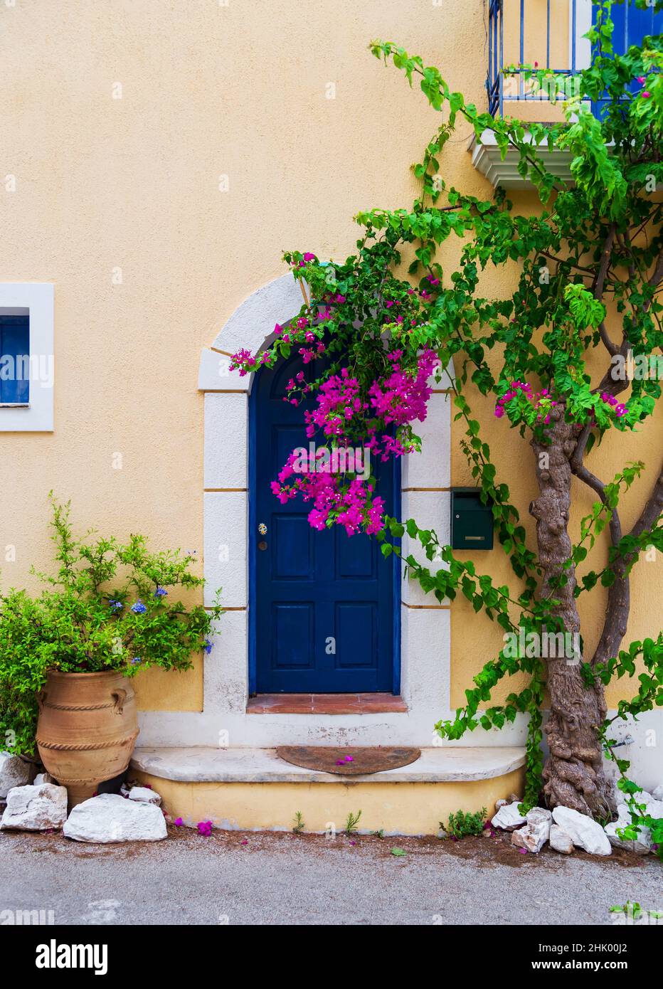 Colorful blue door of traditional greek house with yellow walls at Asos ...