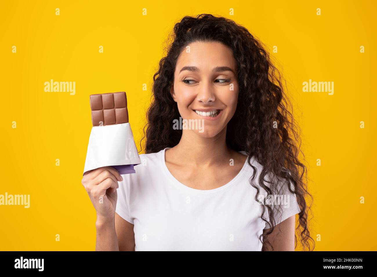 Funny Hungry Lady Holding Chocolate At Studio Stock Photo