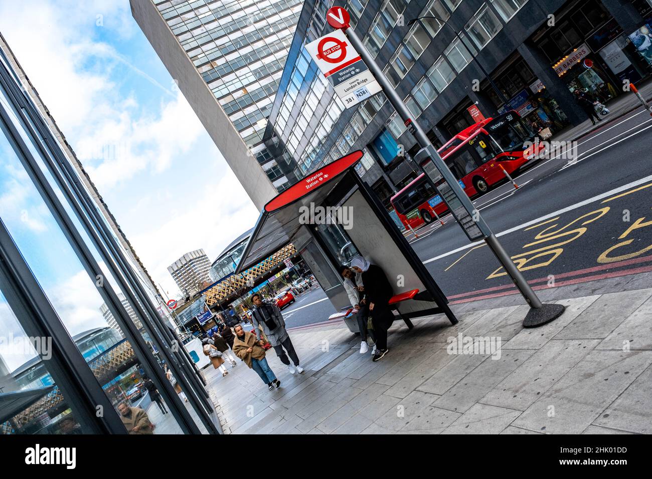 London England UK, 29 January 2022, People Sitting and Walking Past A Public Bus Stop and Shelter Waterloo London Stock Photo