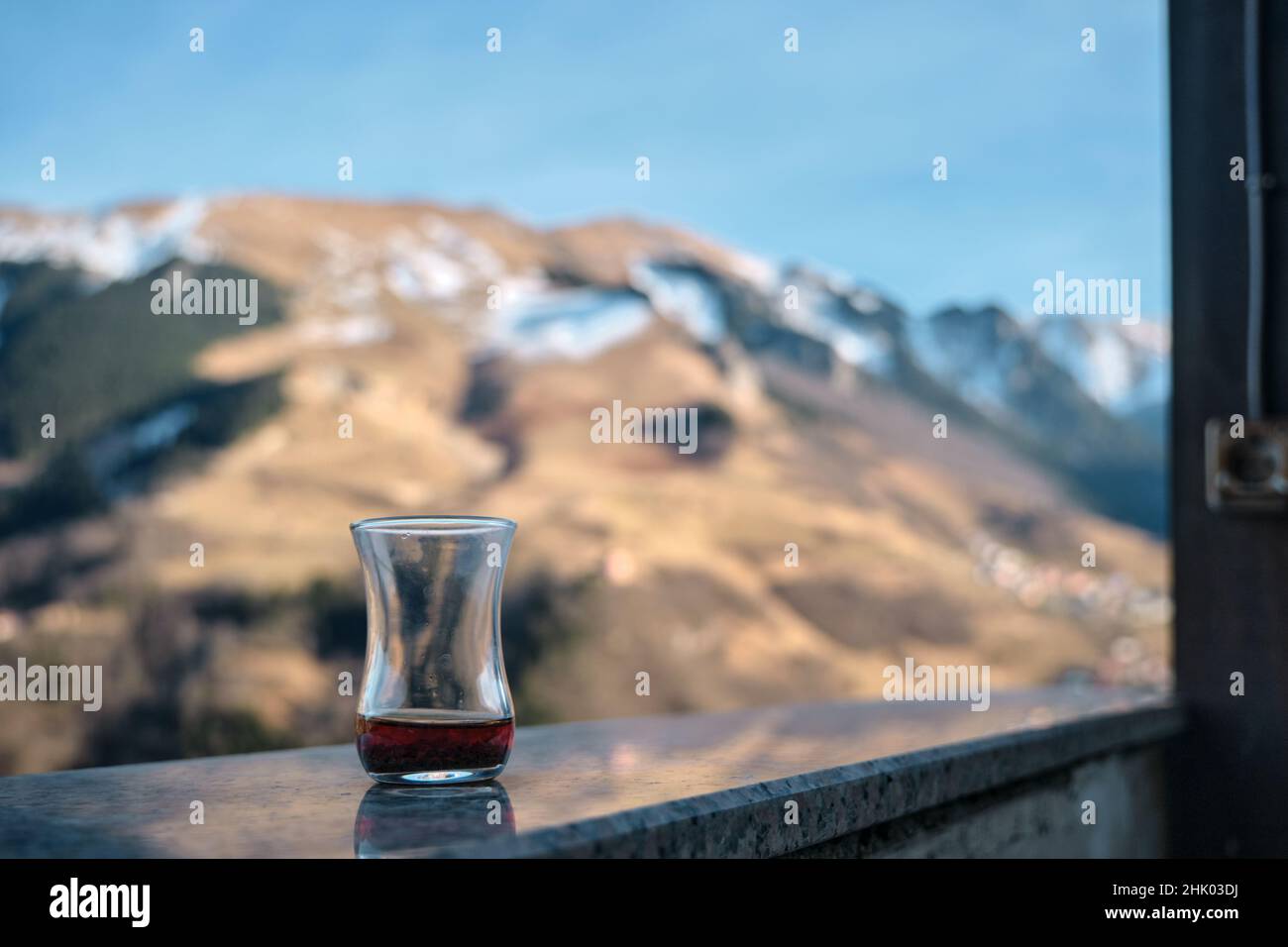 slim waisted tea glass. finished traditional turkish tea and reflection on marbles stone in macka, hamsikoy trabzon. Stock Photo