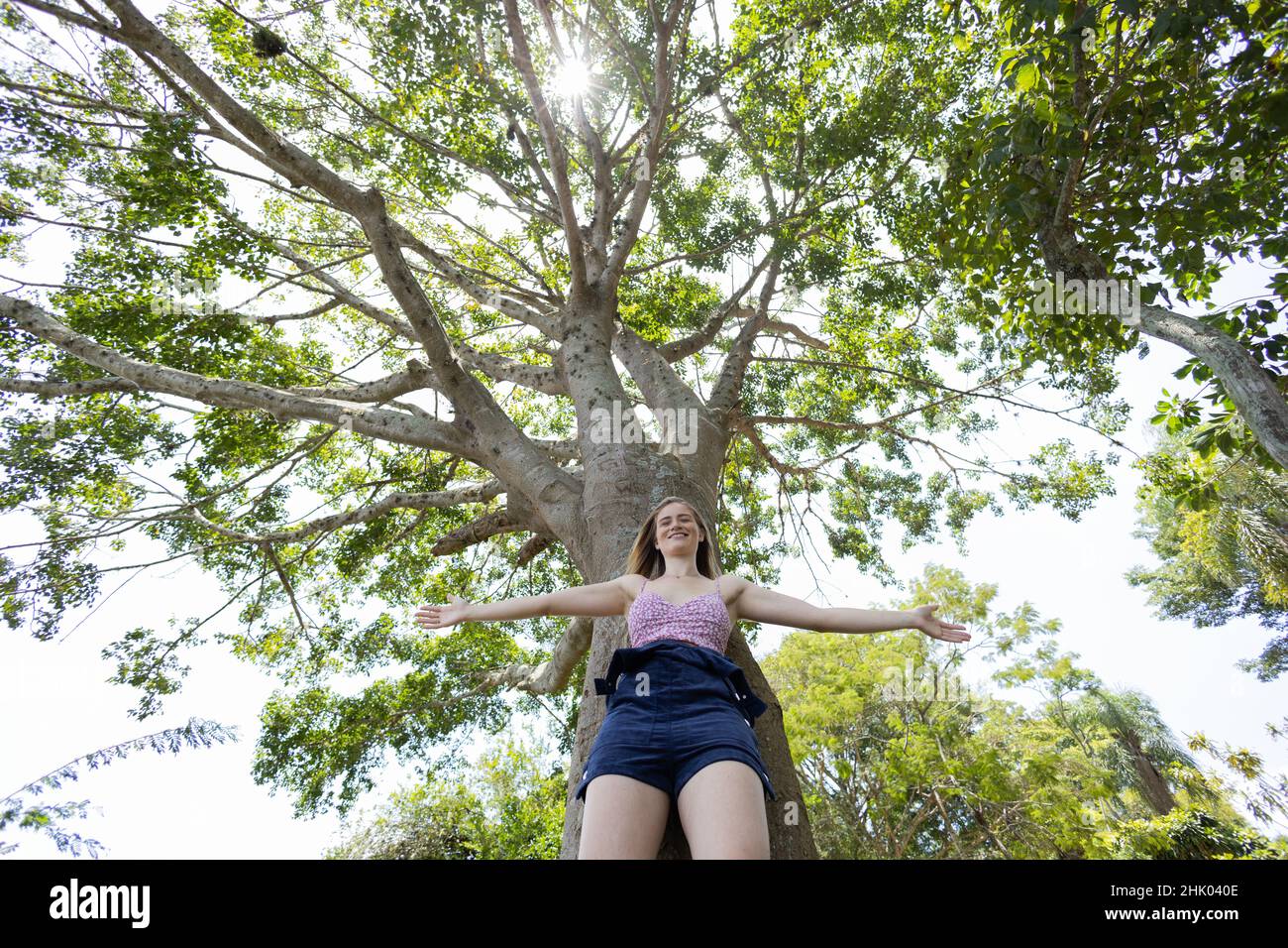 Portrait of smiling young woman at a park on a beautiful sunny day ...