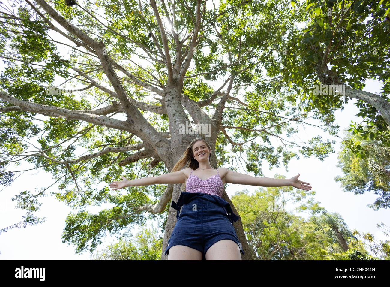 Portrait of smiling young woman at a park on a beautiful sunny day ...
