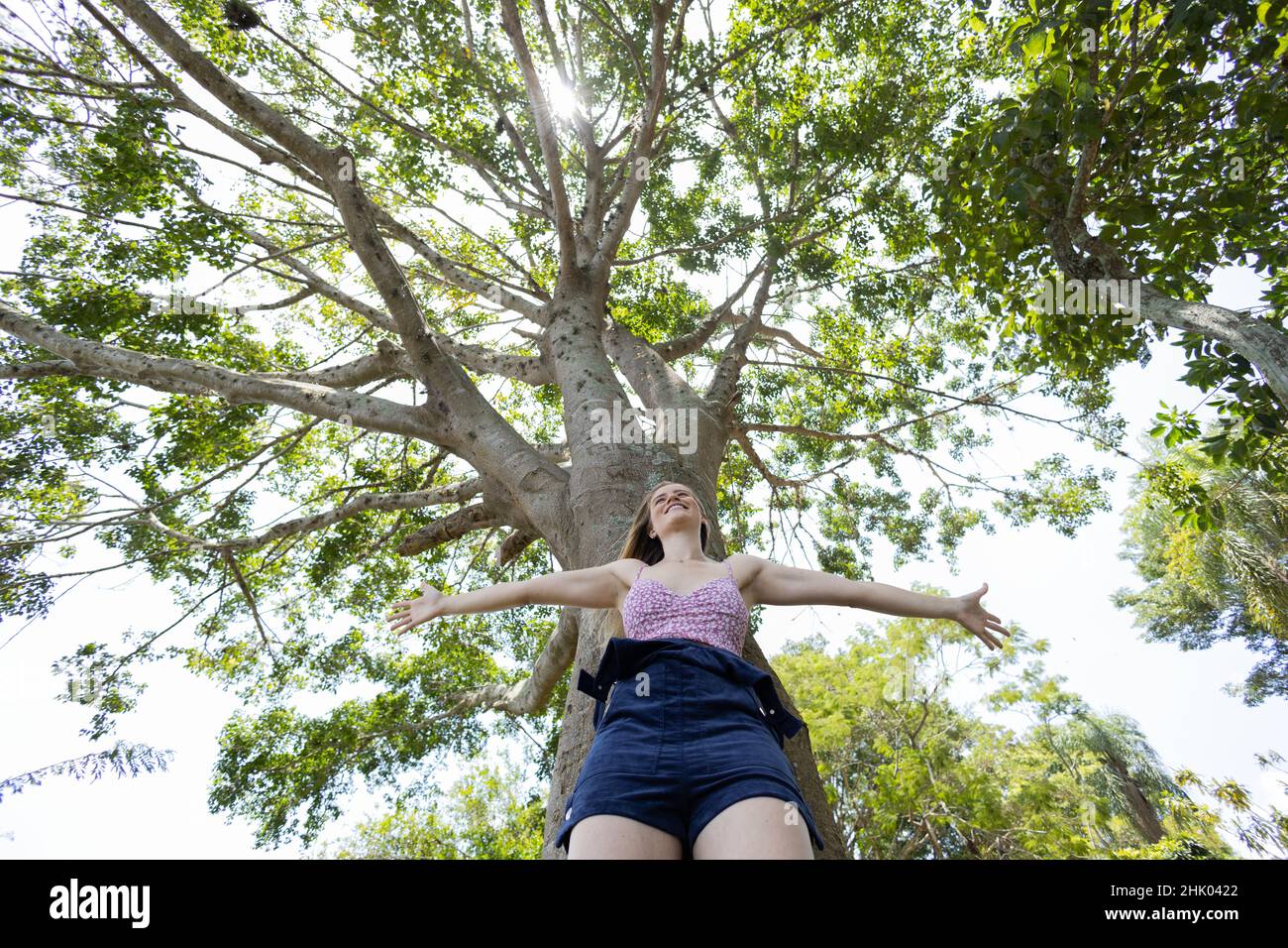 Portrait of smiling young woman at a park on a beautiful sunny day ...