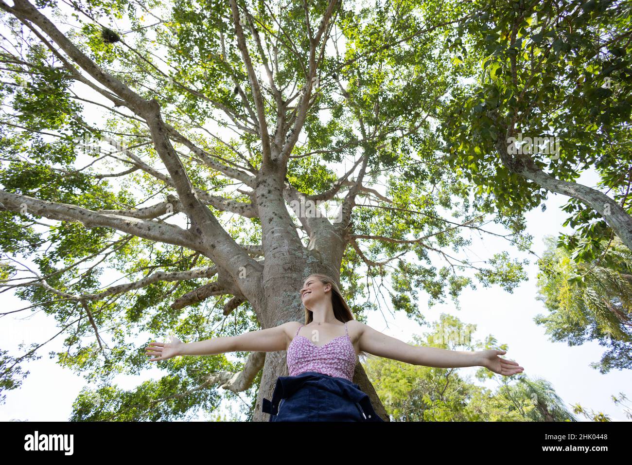 Portrait of smiling young woman at a park on a beautiful sunny day ...