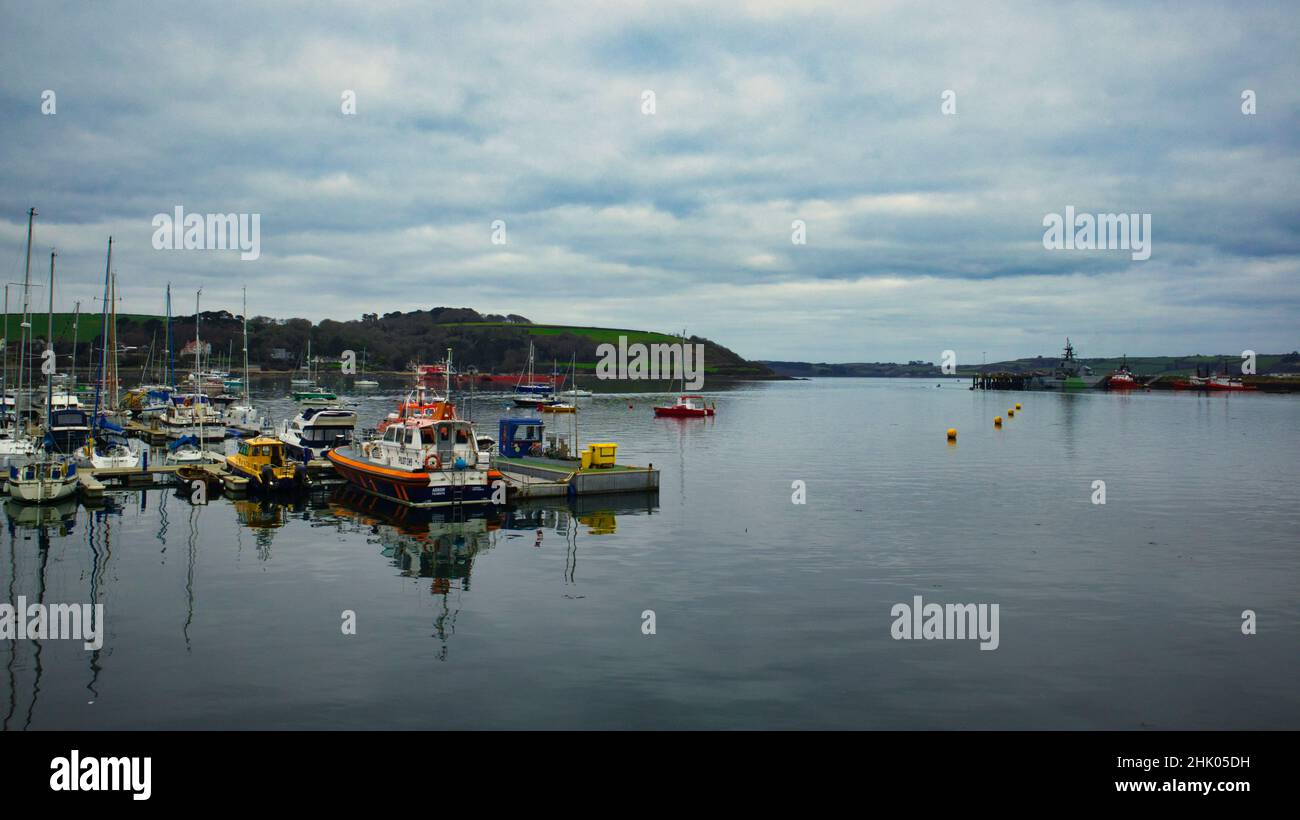 Falmouth harbour looking out to sea with boats in the harbour and a navel ship in the distance Stock Photo