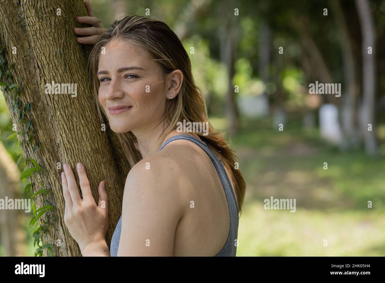 Portrait of smiling young woman at a park on a beautiful sunny day ...