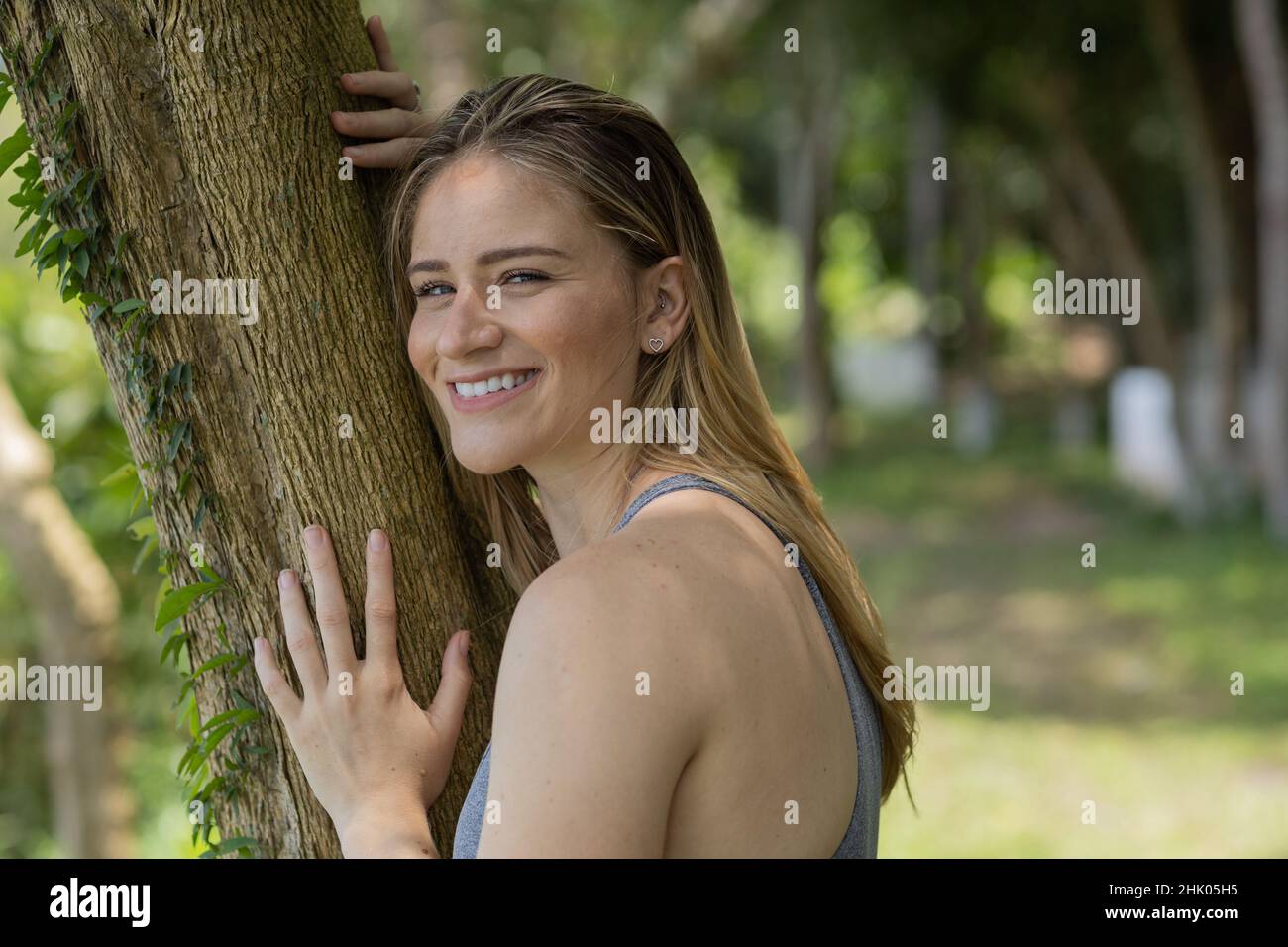 Portrait of smiling young woman at a park on a beautiful sunny day ...
