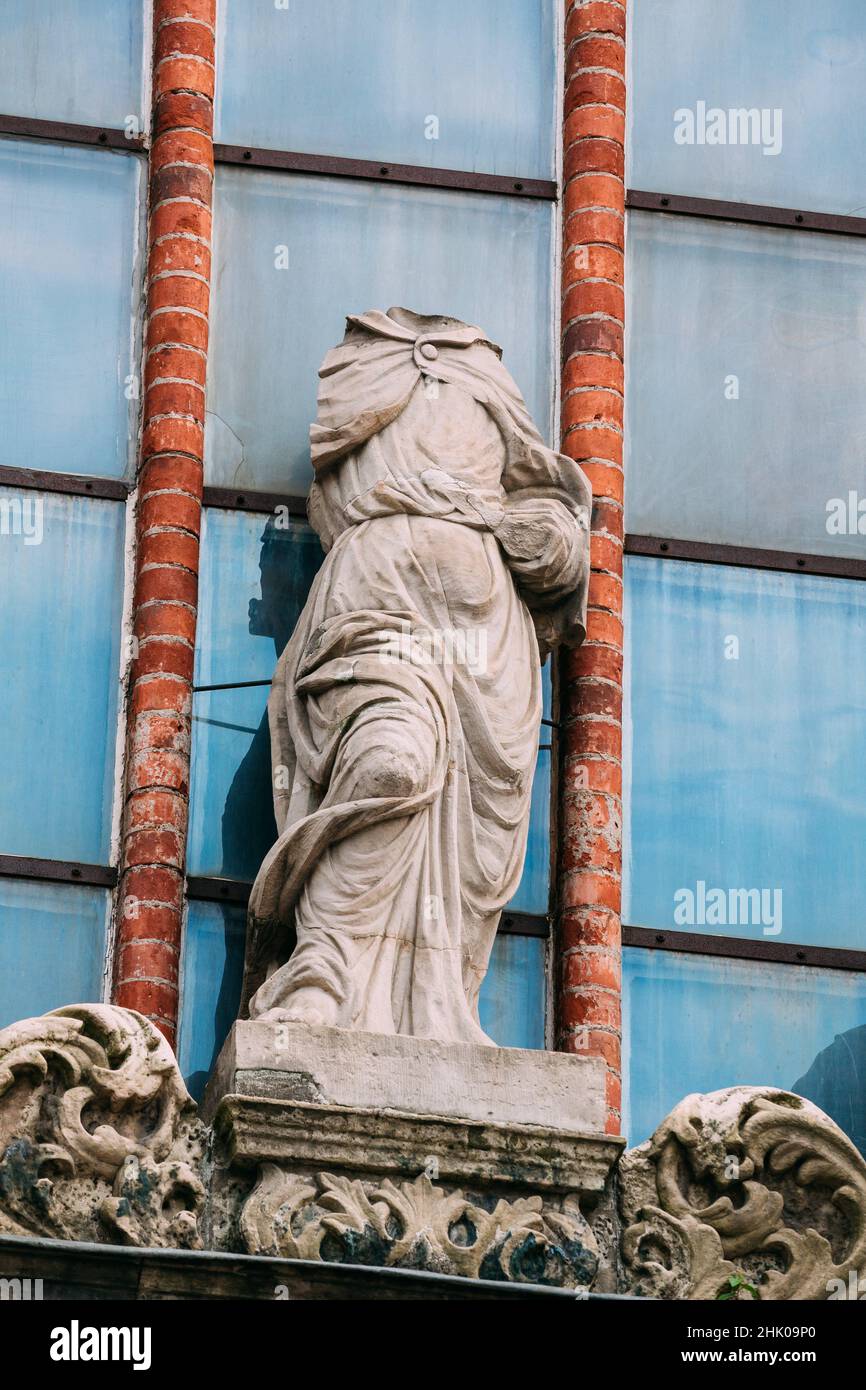 Riga, Latvia. Close View Of Ancient Headless Statue Of Woman In Baroque Style On The Facade