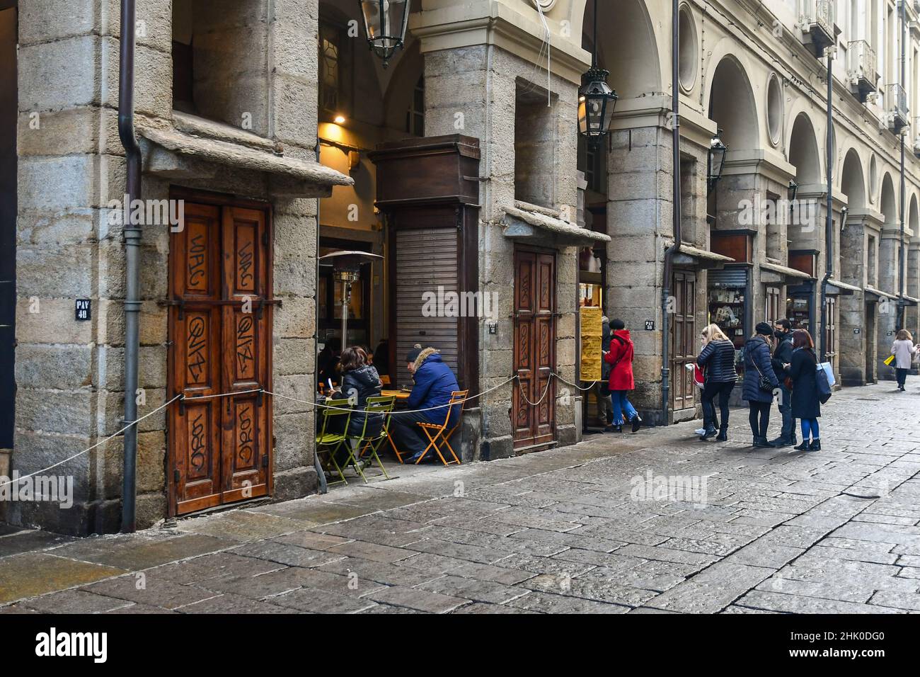People queuing during the lunch break to access a restaurant under the arcades of Via Palazzo di Città in the historic centre of Turin, Piedmont Stock Photo