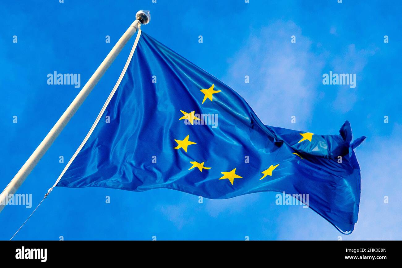 European Union Flag Waving in the Wind with Blue Sky Background. Stock Photo