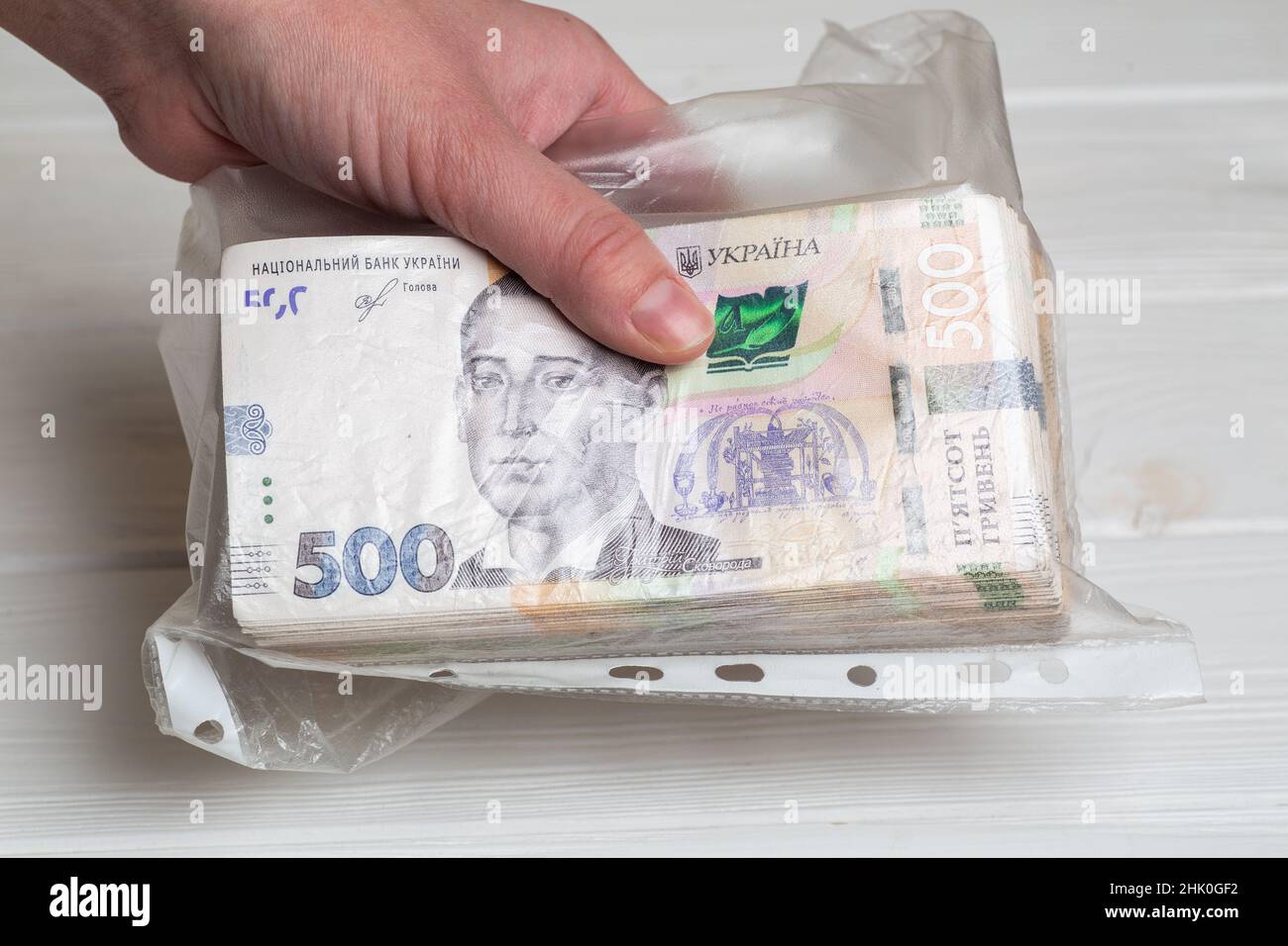 Money of Ukraine. Stack of ukrainian hryvnia banknotes in plastic transparent bag in hands as bribe concept 500 uah Stock Photo