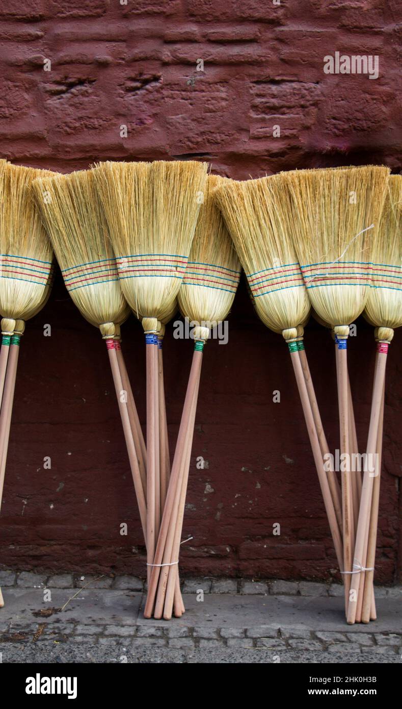 Set of yellow straw broom in a bazaar. Stock Photo