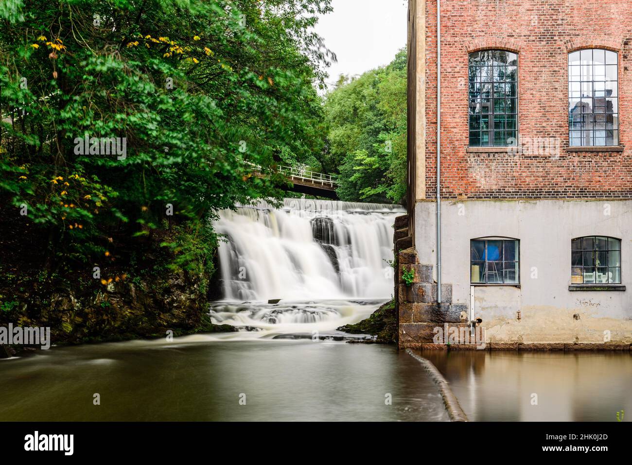 Old industrial building and waterfall in Akerselva River in Kuba Park in Grunerlokka quarter in Oslo. Stock Photo