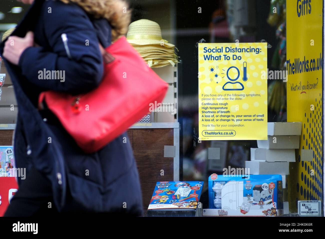 A sign displayed in a High St shop outlining advice on not entering the store if the customer has one of a number of covid symptoms Stock Photo