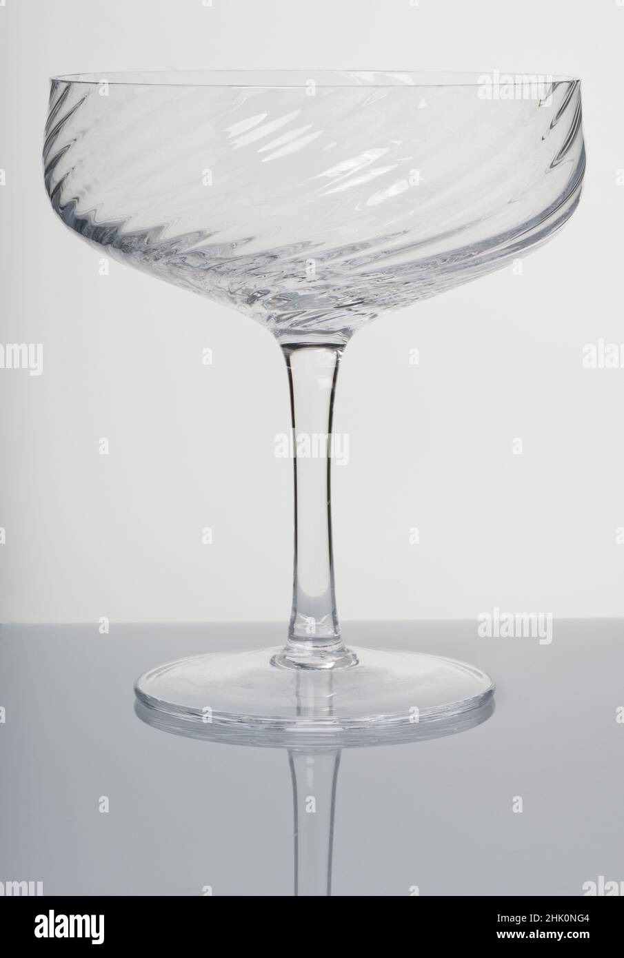 A Champagne coupe glass. Glassware. Drinking vessels or drinkware. Domestic glasses for drinking liquids from. Stock Photo